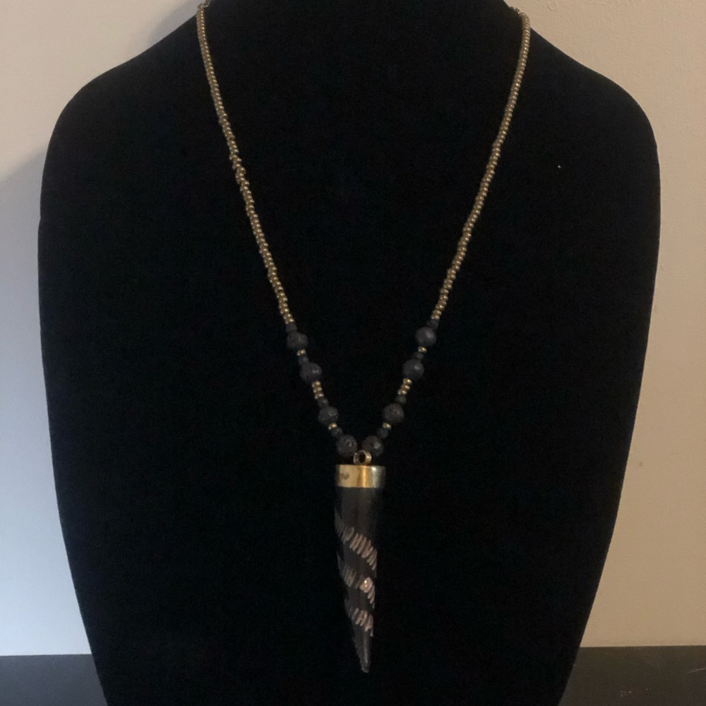 Carved black horn pendant with black lava and brass accent beads.